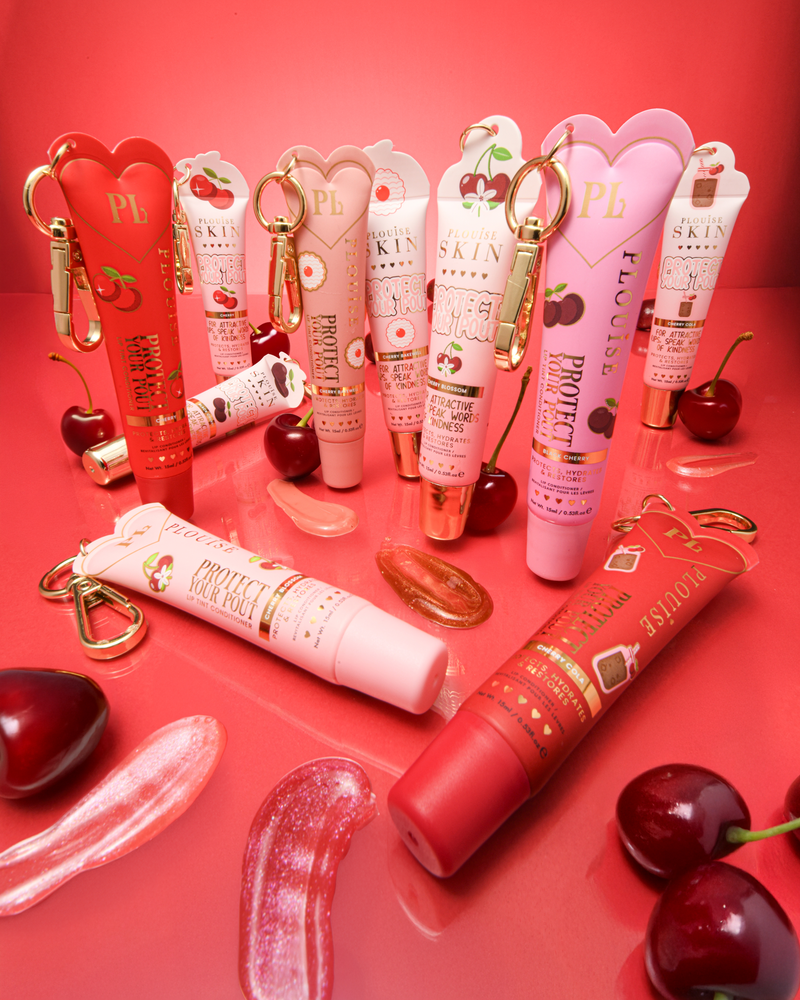 Une collection de cerises roses et rouges protège vos revitalisants pour les lèvres avec des échantillons et des cerises placés autour d'eux sur un fond rouge