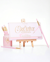 Une palette de fards à paupières arc-en-ciel P.Louise Creative Comeback XXXL rose fermée placée sur un chevalet d'art entouré de pinceaux de maquillage