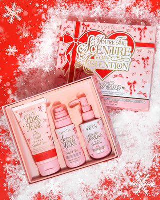 Pink box of P.Louise Youre The Scentre of Attention Body Gift Set in Candied Cove scent with a festive designed package against a red background covered in snow