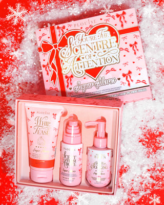 Pink box of P.Louise Youre The Scentre of Attention Body Gift Set in Sugar Shores scent with a festive designed package against a red background covered in snow