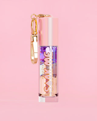 P. Louise Soak Me Lip Oil with colourful layered oil in a pink tube with a gold clasp on a pink background