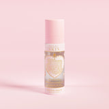 Un flacon pulvérisateur rose étiqueté « P.Louise SKIN » avec une représentation d'un cœur et quelques éléments floraux, contenant un spray fixateur hydratant.