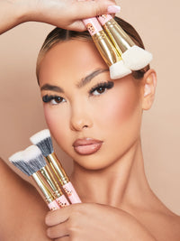 Image d'une femme mannequin maquillée tenant le lot de 5 pinceaux de maquillage P.Louise Spoiled For Choice contre son visage.