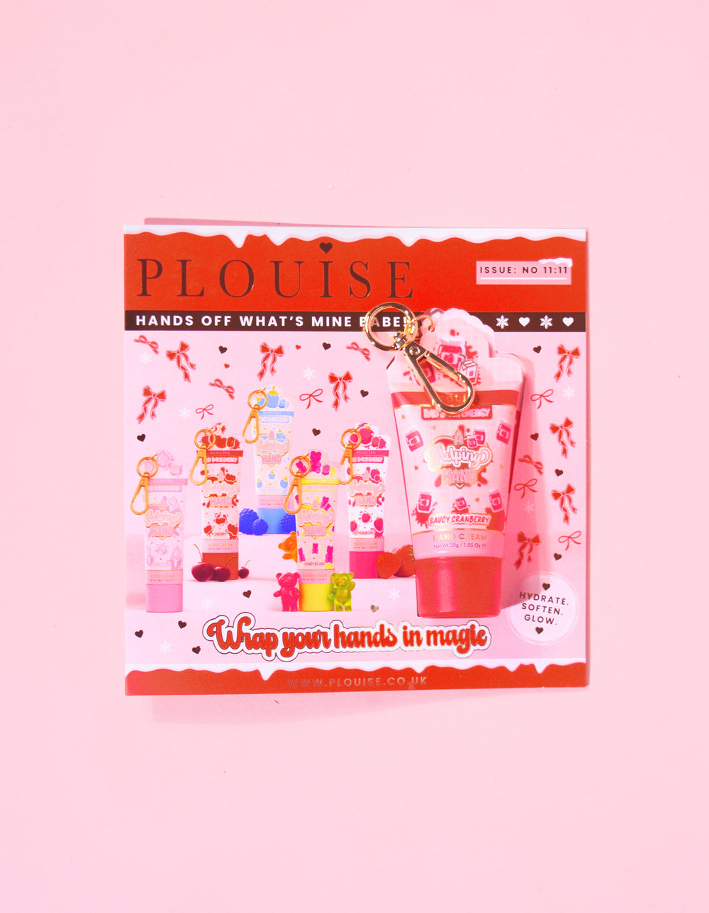 Magazine de Noël P.Louise comprenant un mini porte-clés crème pour les mains en sauce aux canneberges attaché au magazine avec un design festif rouge et rose